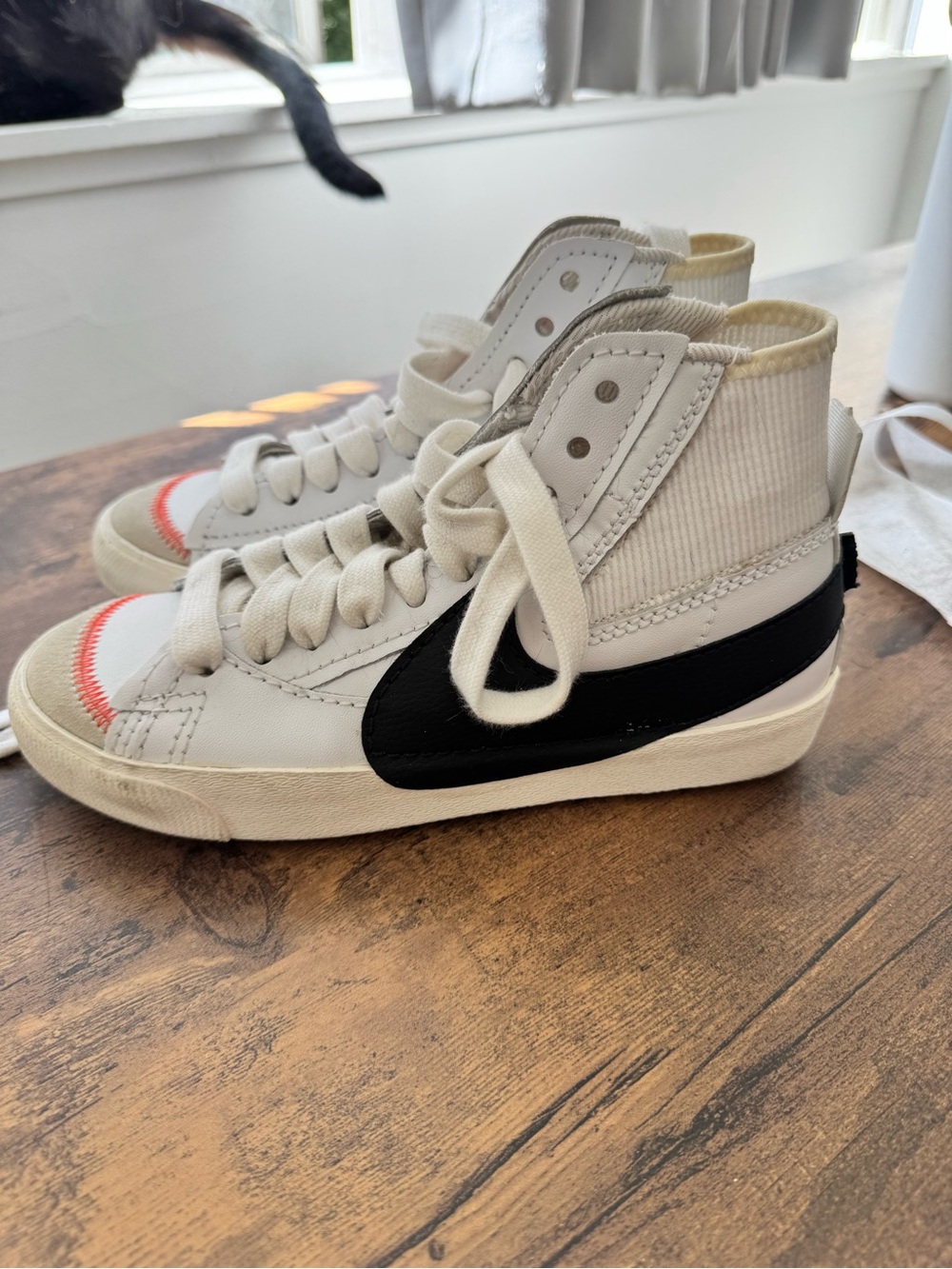 Nike Kids High-Top Sneakers in White with Black Swoosh and Orange Stitching